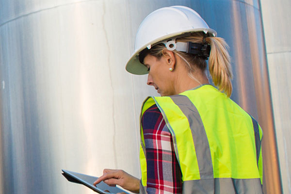 A water entities employee inspecting equipment in safety gear